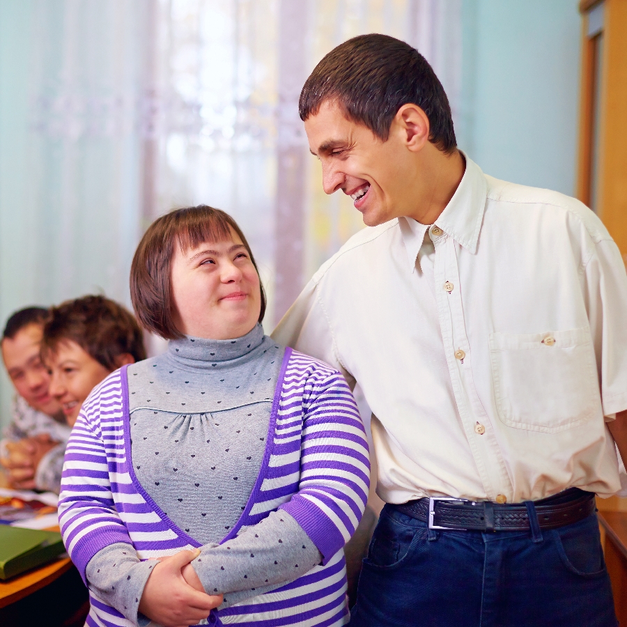 A man smiling with a woman with Downs syndrome