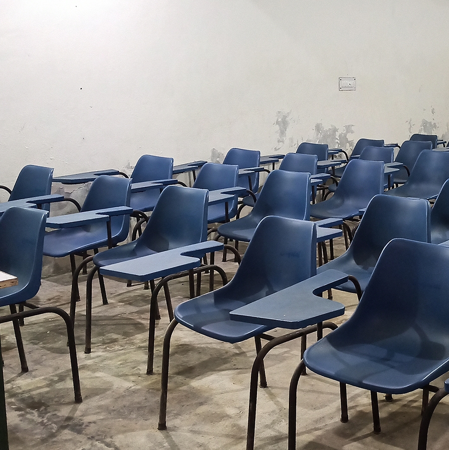 Rows of worn blue desk chairs