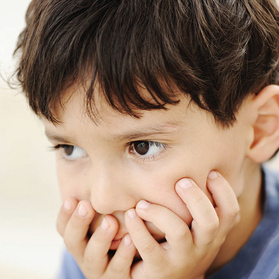 Close up of a sad boy with his hands on his face