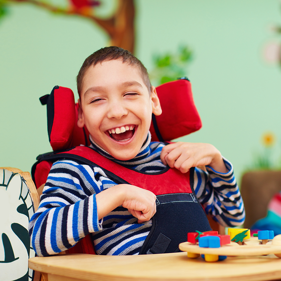 Smiling child with CP in a classroom